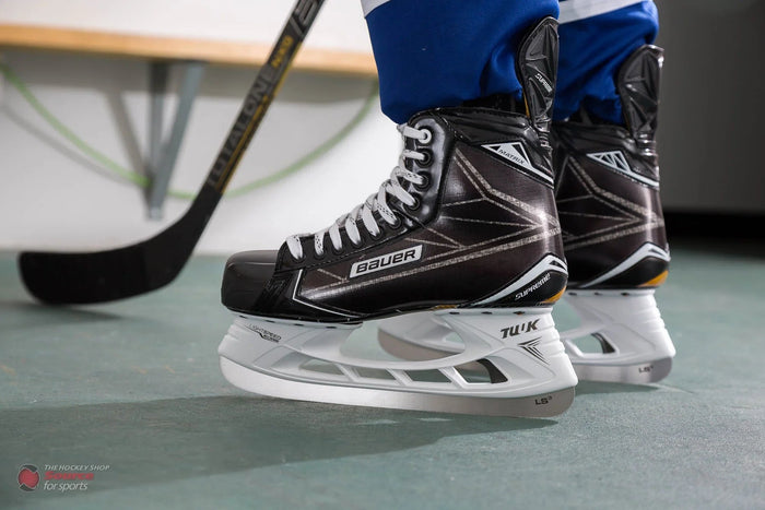 Bauer Supreme Matrix hockey skates on player, blue pants, hockey stick, The Hockey Shop