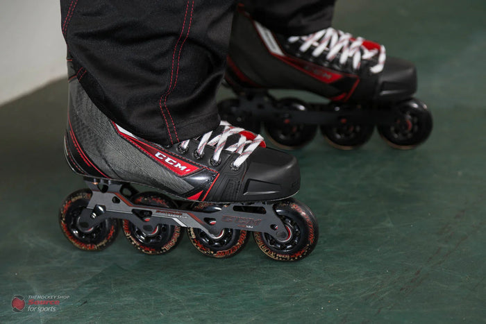 CCM Jetspeed inline hockey skates with black and red boots on green floor, The Hockey Shop