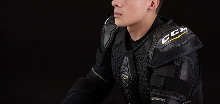 Close-up of CCM hockey shoulder pads worn by player, black background, TheHockeyShop.com