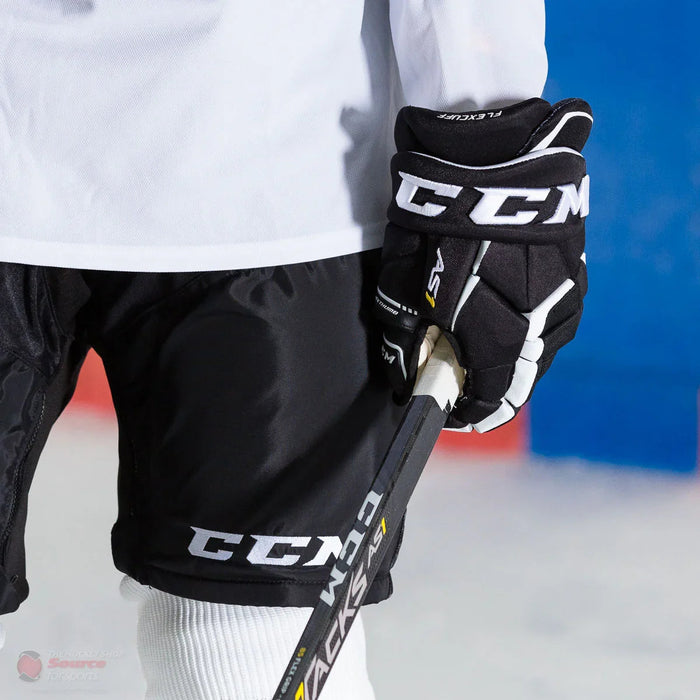 CCM Super Tacks AS1 hockey gloves and stick on ice, The Hockey Shop equipment