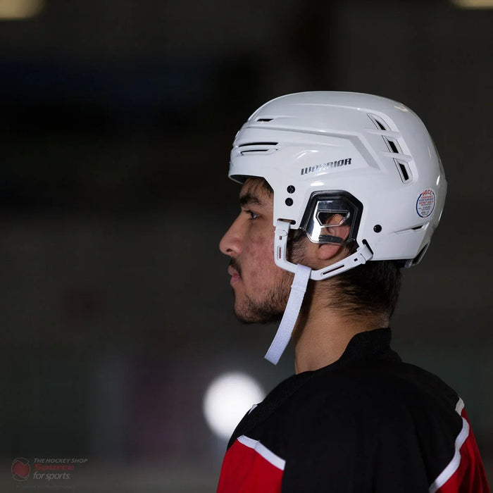 Warrior Alpha One hockey helmet in white worn by player, side view on ice rink