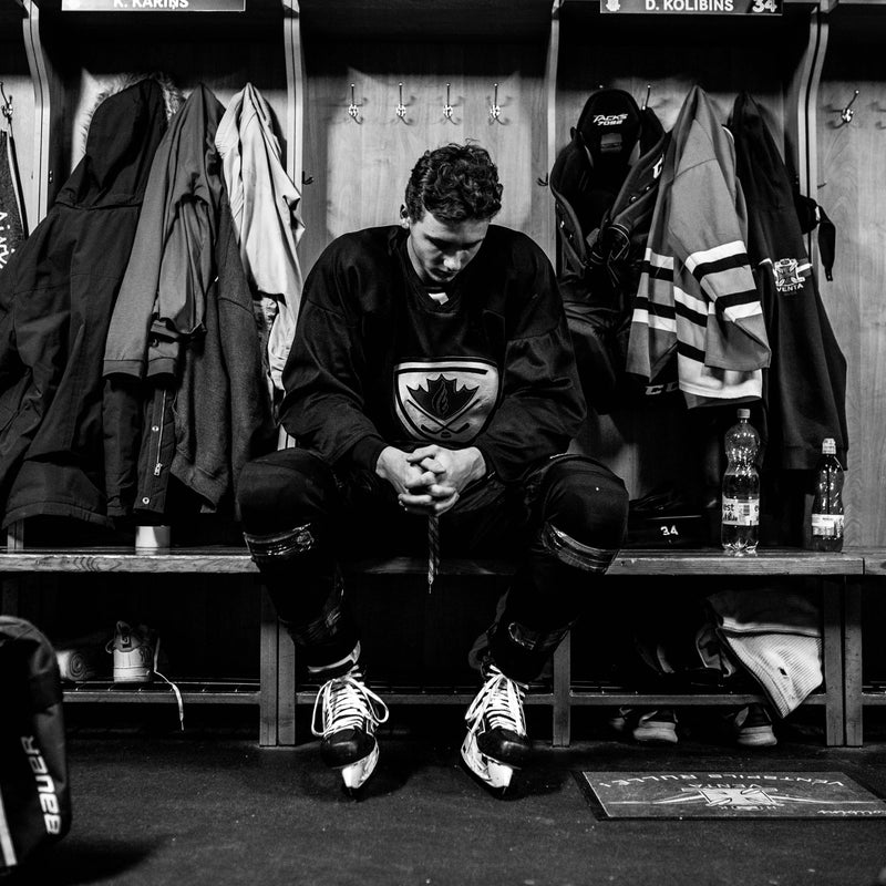 Hockey player at his dressing room stall prepping mentally for his upcoming hockey game