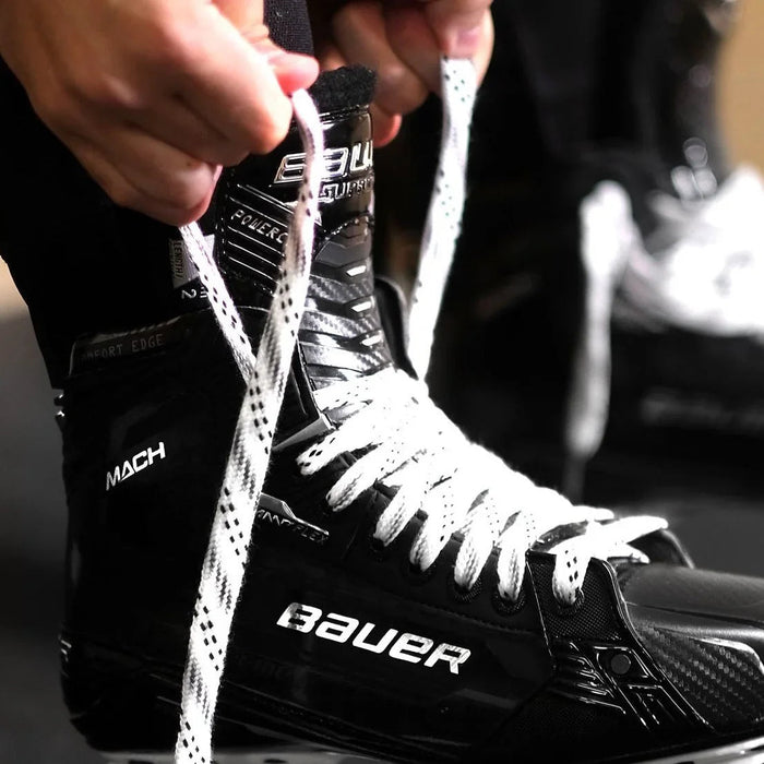 Hands tying Bauer MACH hockey skate laces, close-up from The Hockey Shop equipment selection