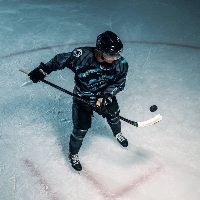 Trevor Zegras playing tossing a puck in the air with a Bauer Twitch stick