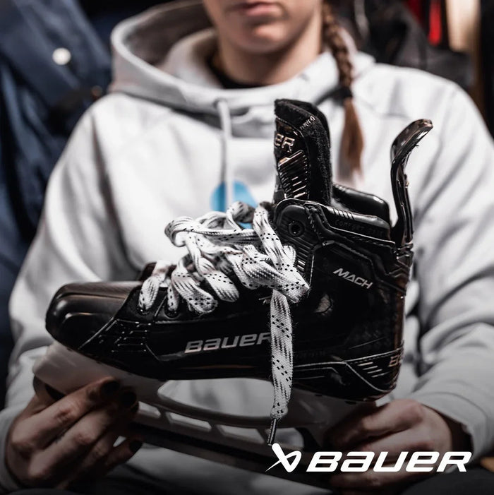 Person holding Bauer Mach hockey skate, close-up view, TheHockeyShop.com equipment selection