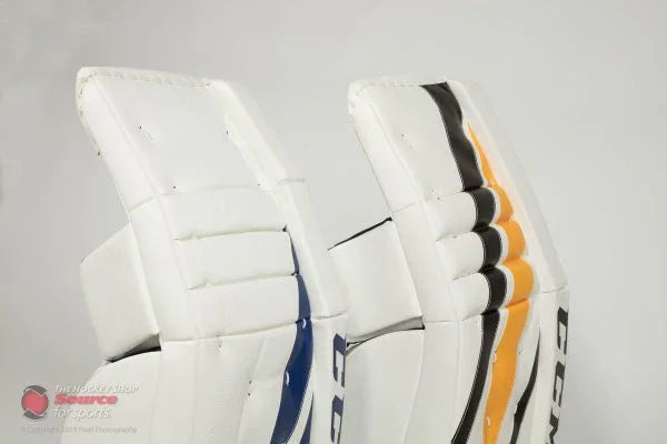 CCM goalie leg pads with blue and orange accents, The Hockey Shop equipment close-up