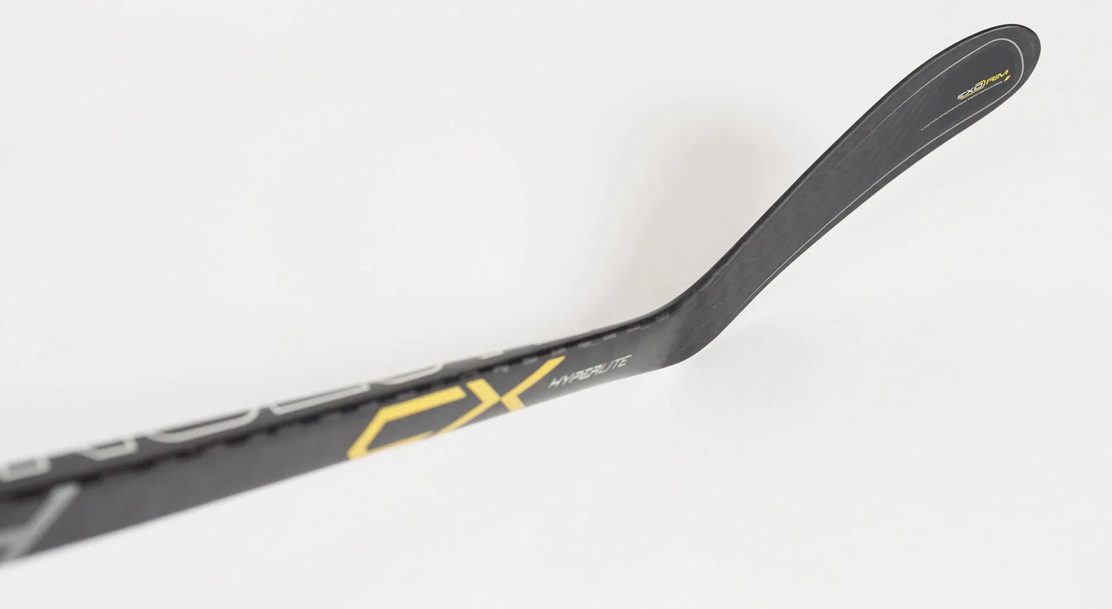 Close-up of Bauer hockey stick blade with black and yellow CX Hyperlite graphics on white background