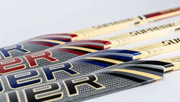 Bauer Supreme hockey sticks with red, blue, and gold accents at The Hockey Shop