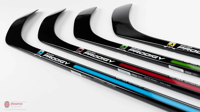 Four Bauer Prodigy hockey sticks with colored accents, displayed at The Hockey Shop