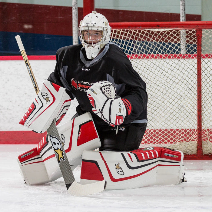Hockey goalie in Brian's Optik 9 pads with stick, in front of net at ice rink, TheHockeyShop.com