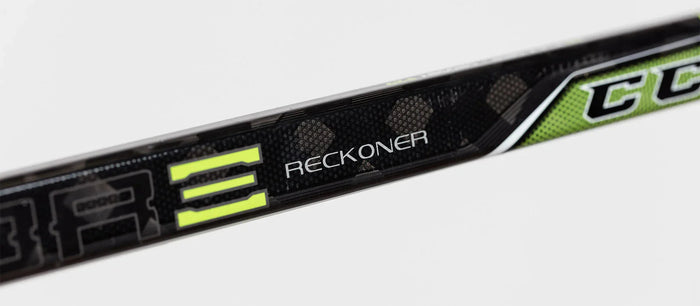 Close-up of CCM Ribcor Reckoner hockey stick shaft with black, green, and yellow design