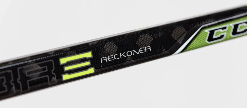 Close-up of CCM Ribcor Reckoner hockey stick shaft with black, green, and yellow design