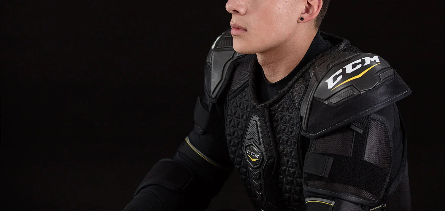 Close-up of CCM hockey shoulder pads worn by player, black background, TheHockeyShop.com
