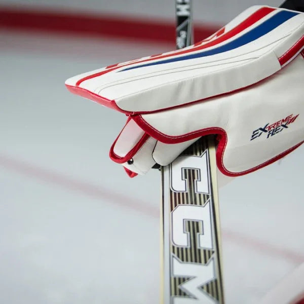 CCM Extreme Flex goalie blocker in white, red, and blue with CCM stick on ice rink