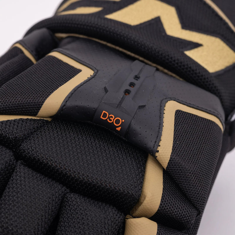 Close-up of CCM Tacks AS-V Pro senior hockey glove in black and gold with D3O protection.