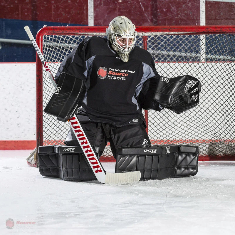 Hockey goalie in full gear with Warrior stick and Vaughn pads in front of net at TheHockeyShop.com rink