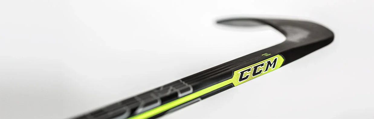 Close-up of CCM Ribcor hockey stick blade, black with neon yellow, on white background