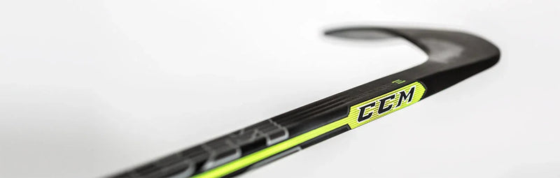 Close-up of CCM Ribcor hockey stick blade, black with neon yellow, on white background
