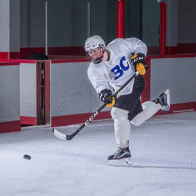 Hockey player in CCM gear shooting puck on ice rink at TheHockeyShop.com