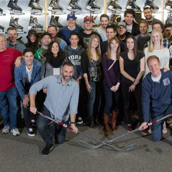 The Hockey Shop staff group photo in store with hockey skates wall display
