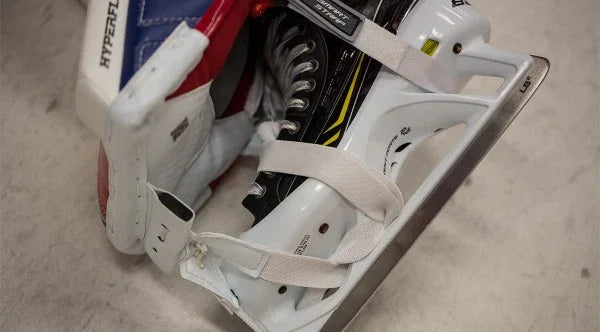 Brian's goalie skate and pad with white straps on ice, hockey equipment at TheHockeyShop.com