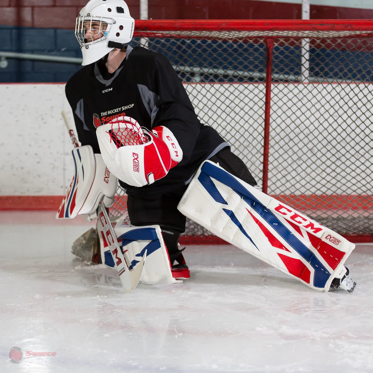 Goalie wearing CCM E-Flex 4 pads and blocker in front of hockey net at The Hockey Shop rink