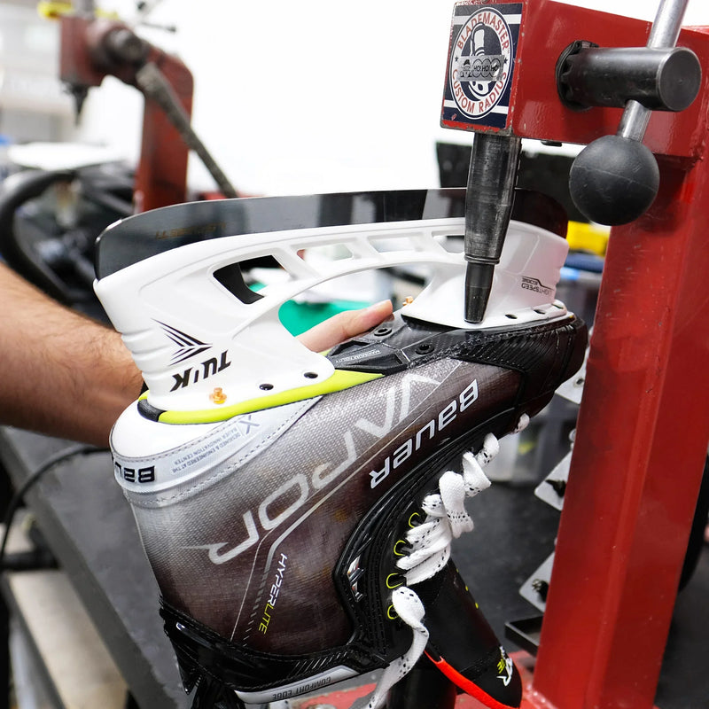 person doing maintenance on a hockey skate