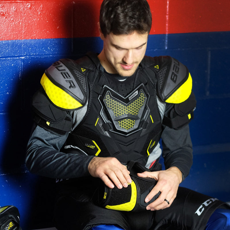 hockey player adjusting an elbow pad