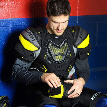 hockey player adjusting an elbow pad