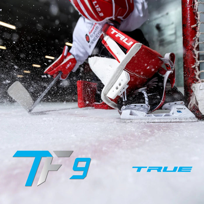 Hockey goalie in red and white pads making a save on ice, featuring True TF9 skates.