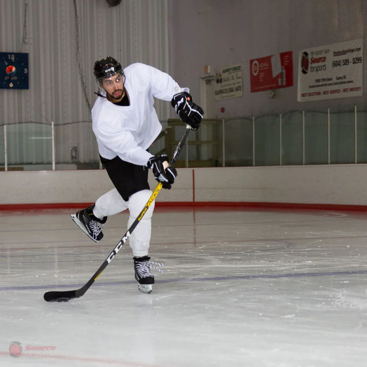 Hockey player shooting with CCM Super Tacks stick on indoor ice rink, TheHockeyShop.com