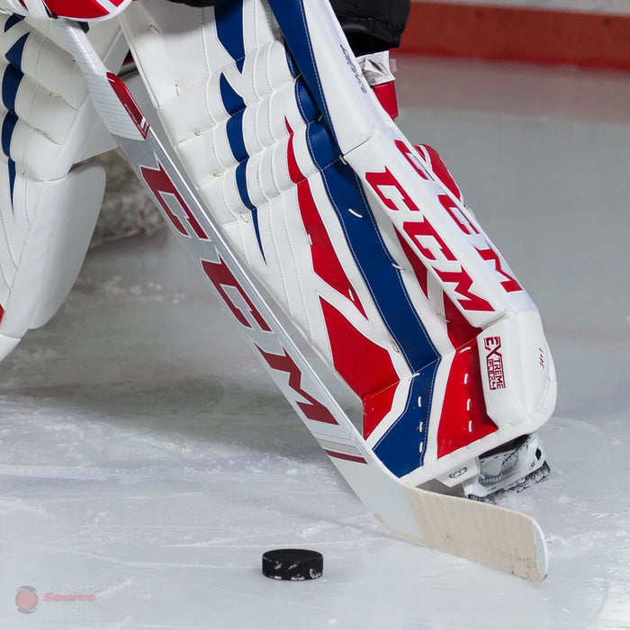 CCM EFlex 4 goalie leg pads and stick blocking puck on ice, hockey goalie equipment
