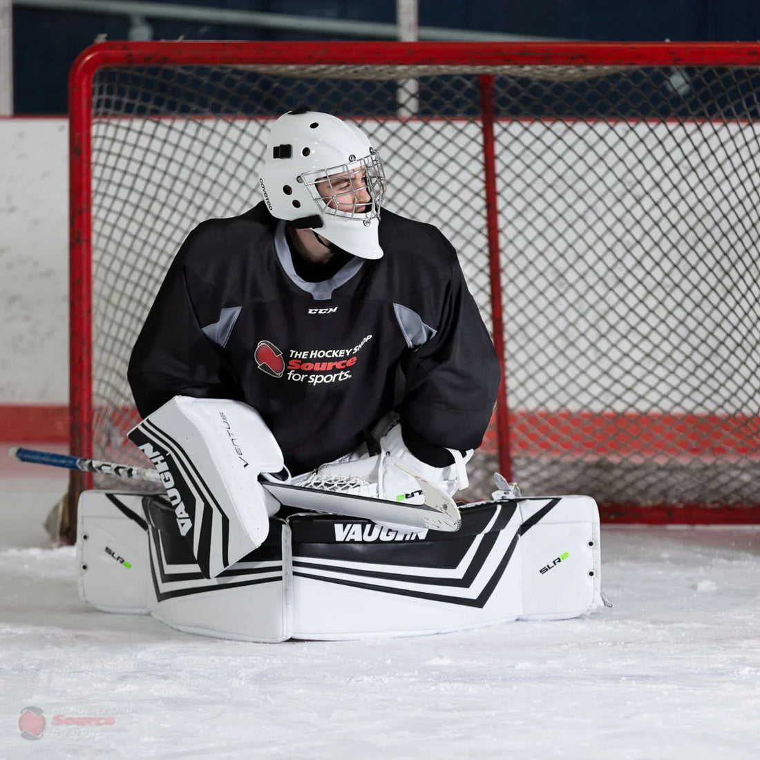 Goalie in white Vaughn Ventus SLR2 Pro Carbon pads at ice hockey rink, The Hockey Shop gear visible