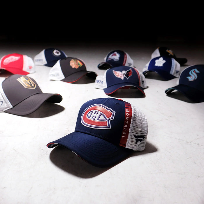 Assorted NHL team logo hats on display at The Hockey Shop, hockey fan merchandise collection