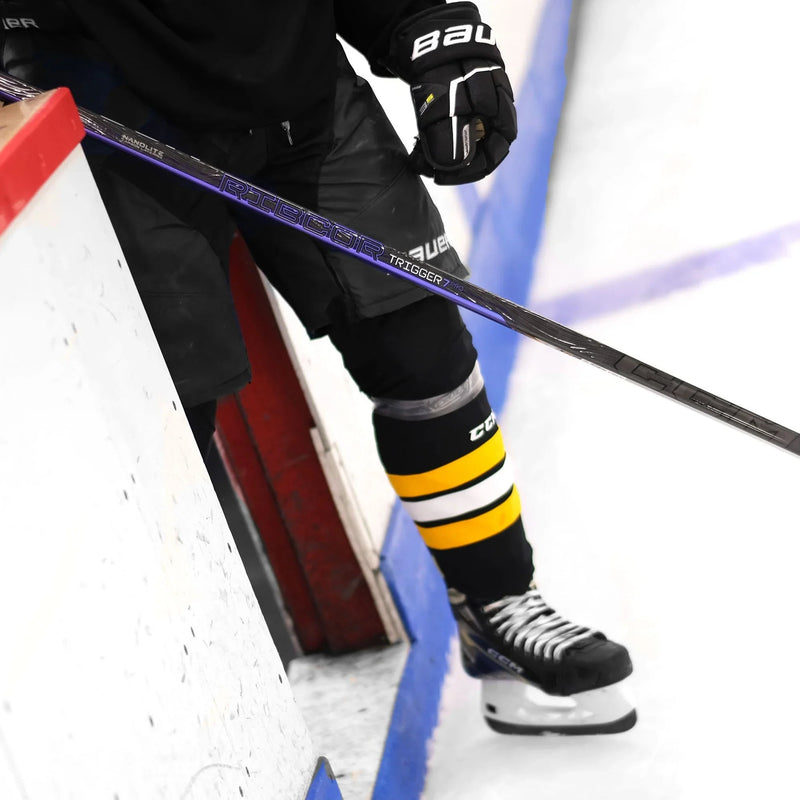 Hockey player in Bauer gear and CCM socks holding Trigger 7 Pro stick on ice rink TheHockeyShop.com