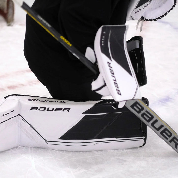 Bauer Supreme Mach goalie leg pads and blocker on ice, hockey equipment at TheHockeyShop.com