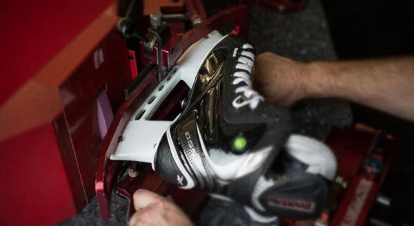 Hockey skate blade being sharpened at The Hockey Shop, skate maintenance equipment visible