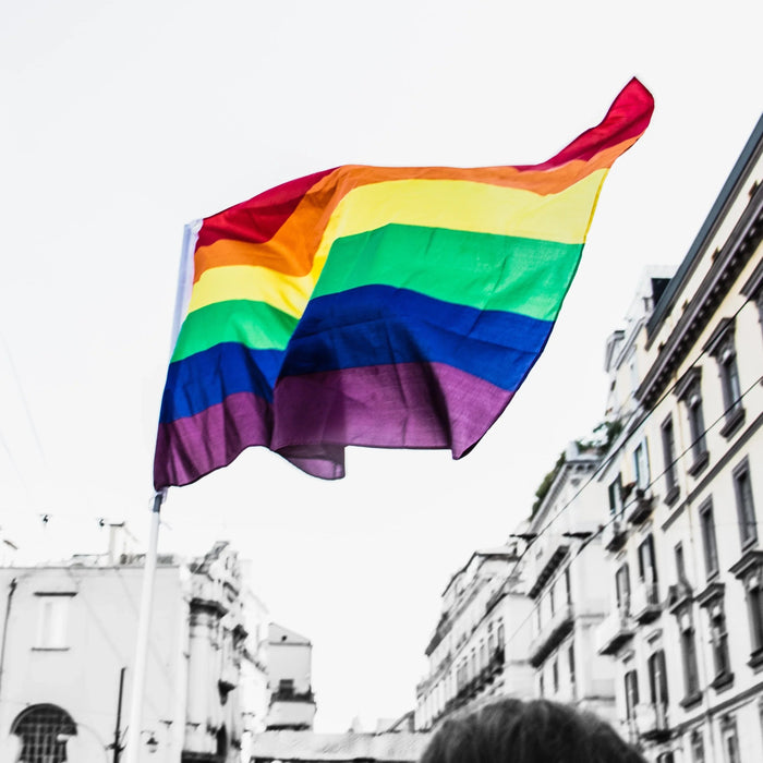 Rainbow pride flag waving in a city street, colorful symbol of LGBTQ+ community support